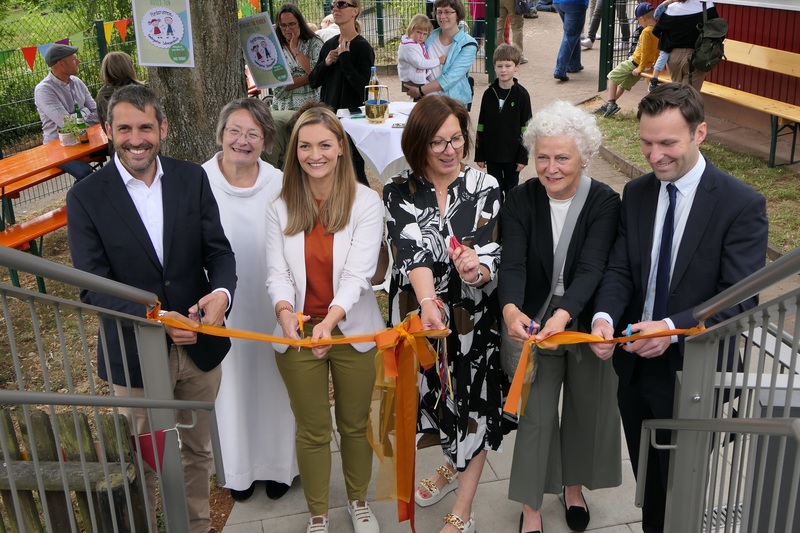 Bild Stimmkreisb�ro: v.li. Landrat Dr. Alexander Leger, Pastoralreferentin Petra Kirchhoff, Staatministerin Judith Gerlach, Kindergartenleiterin Karin Bayer-Braun, Architektin Margarete Els�sser und B�rgermeister Sch�llkrippen Marc Babo beim Durchschneiden des Bandes